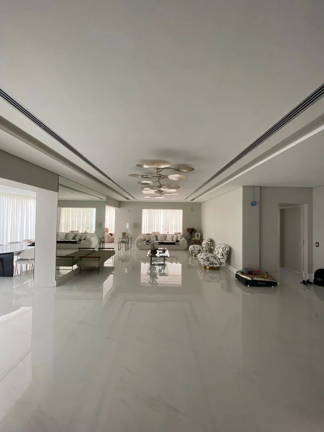 Sala residencial com grelhas lineares nos dois lados do teto